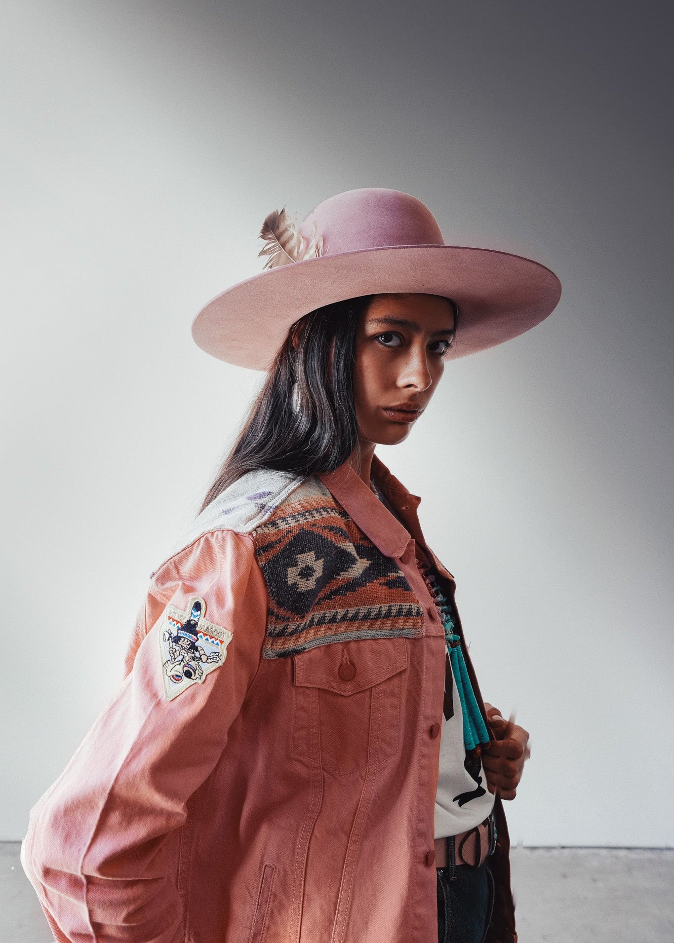 Person wearing a pink hat and patterned jacket against a plain background